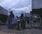 Nancy Harms and Dylan Prichertt portray pioneer woman and a black pioneer at an Oregon Trail wagon encampment.