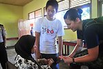 Canadian Air Force Lt. Rebecca Sparkes Screens an Indonesian Woman for Arthritis