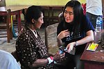 Project HOPE Nurse Ivana Winata Hands an Indonesian Woman a Pair of New Glasses