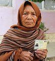 A woman displays her voting card in Samangan province.