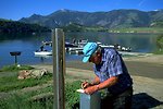Man completing form at fee station at Log Gulch Campground