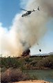 Helicopter bucketing water from the Colorado River to help control a wildfire.