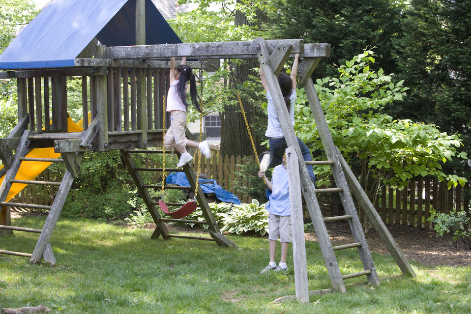 Children love playing outside, and these children were thoroughly enjoying their wooden swing set, and all were having fun in the fresh outd