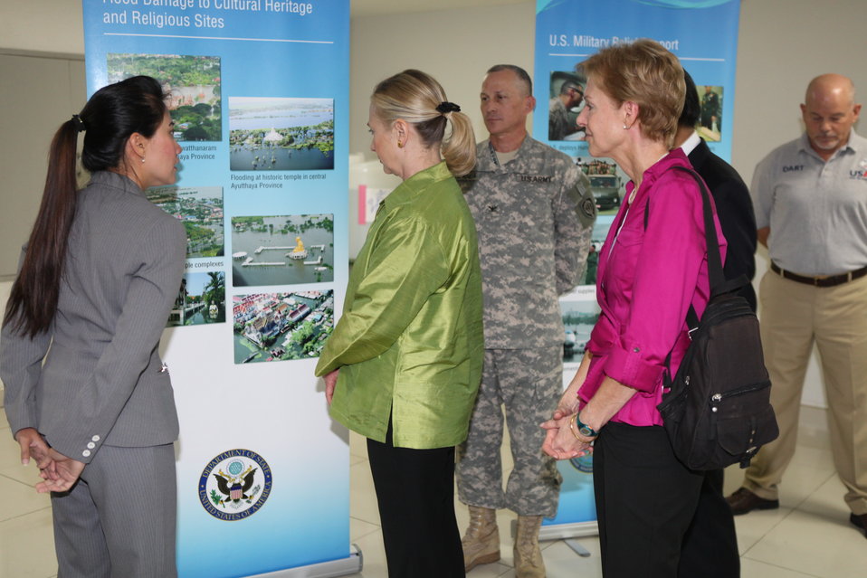 Secretary Clinton, With Ambassador Kenney, Looks at a Presentation of Flood Damage