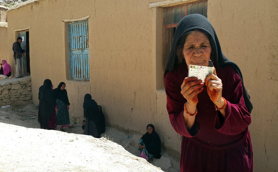 An elderly woman posing for a photo after casting her vote in Daikundi province.