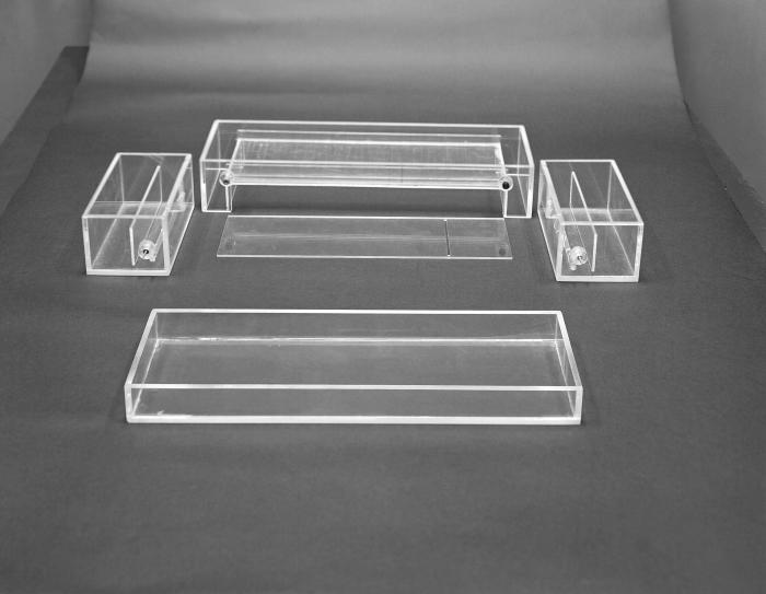 This historic image from 1963 depicts a disassembled starch block electrophoresis apparatus. See PHIL 12023 for an assembled view of this ap