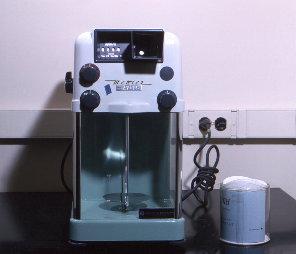 This historic image from 1964 depicts a Mettler single-pan analytical balance. Introduced in 1946 by its creator, Erhard Mettler, the single