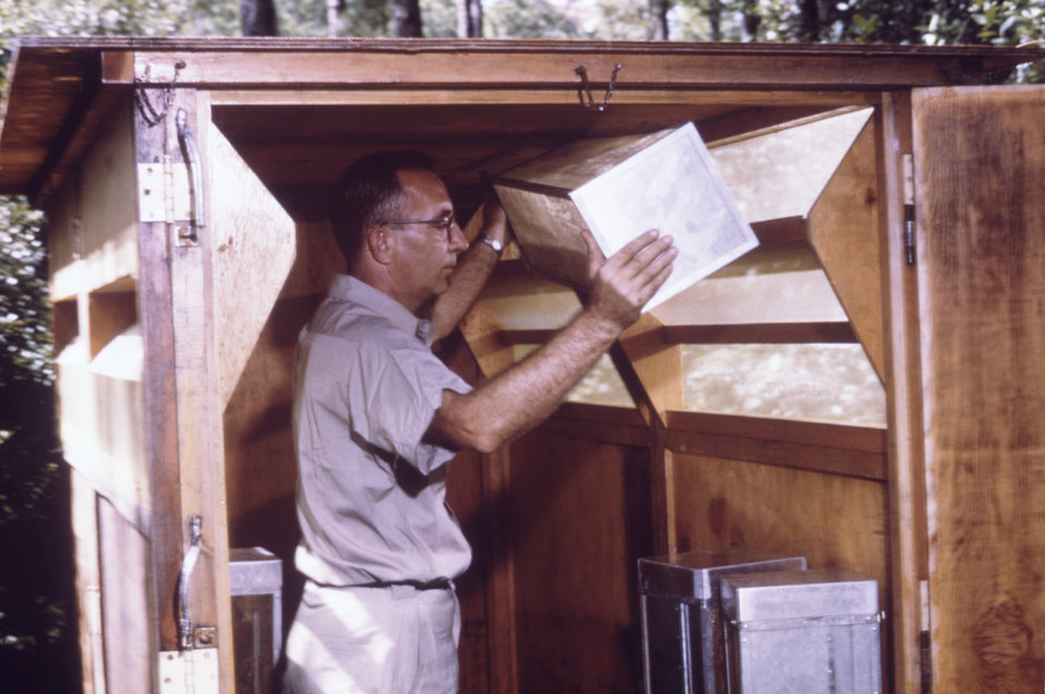 This CDC field researcher is removing a mosquito cage from a horse stable mosquito trap.