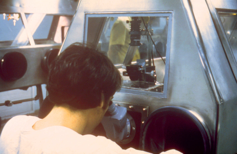 This scientist is working at a microscope sealed in a cabinet line within the Maximum Containment Lab.