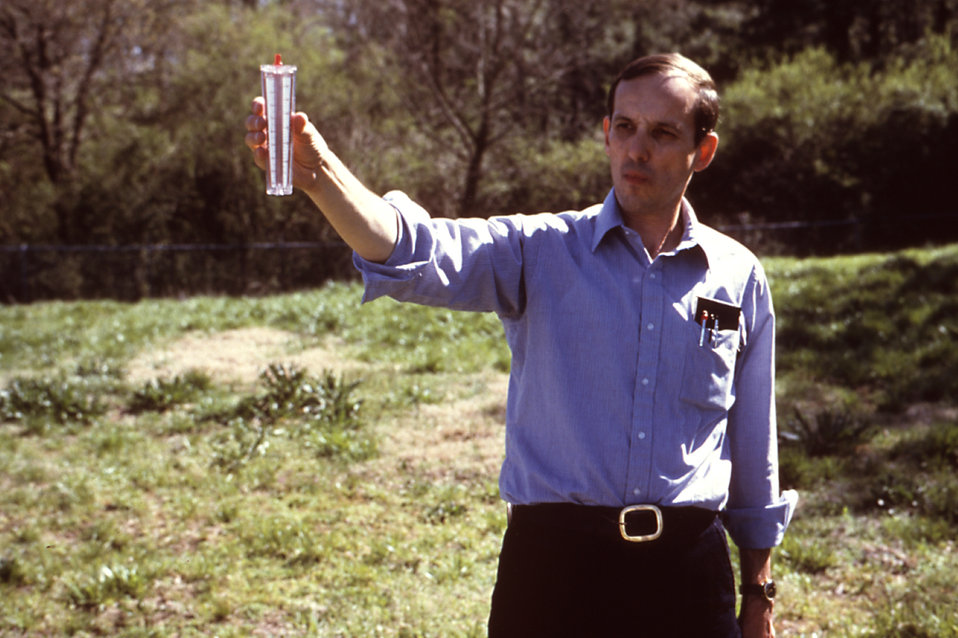 This 1981 photograph depicted a field technician as he used a wind gage in order to measure the wind velocity in the immediate area into whi