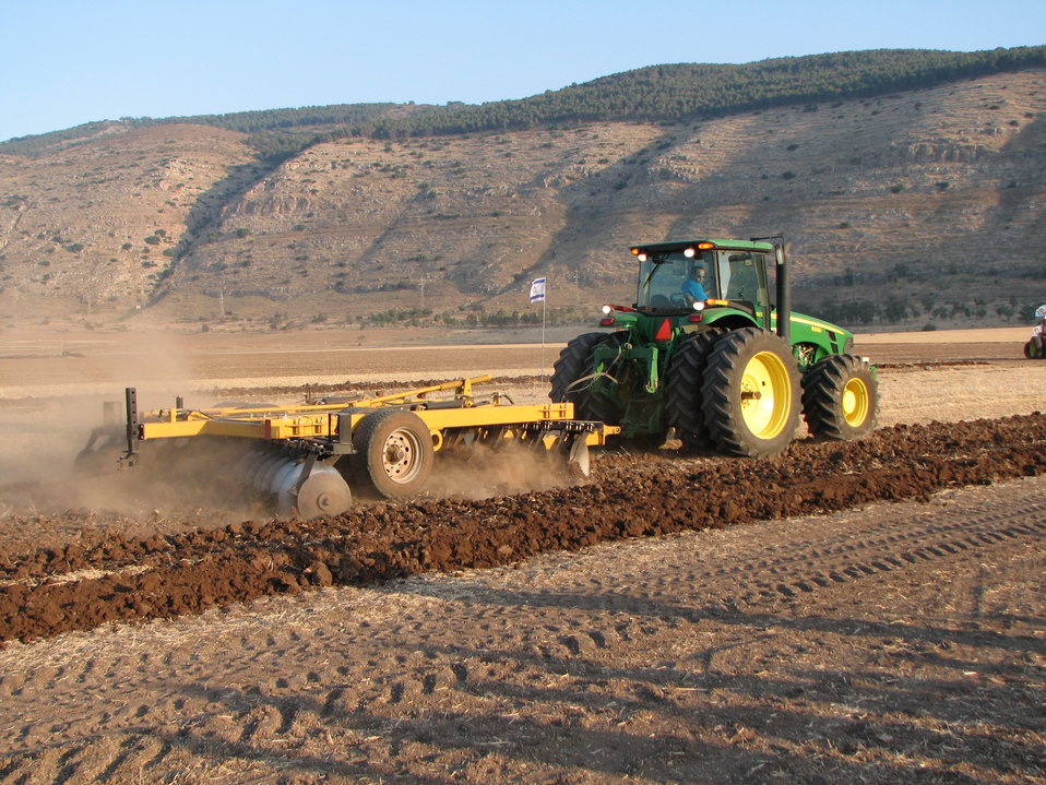 A John Deere 8330 tractor pulling a disc harrow somewhere in Israel עברית:  משדדת דיסקים