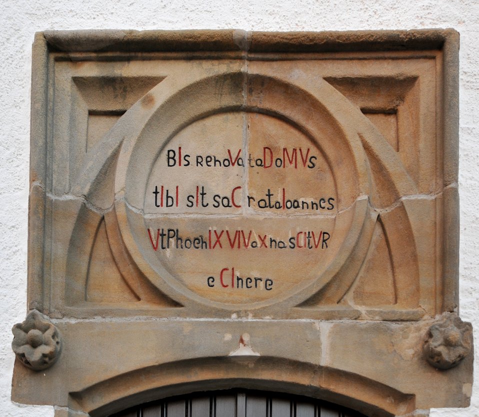 Lëtzebuergesch:  De Chronogram (1859) iwwer der Entree vun der Kierch zu Elveng.