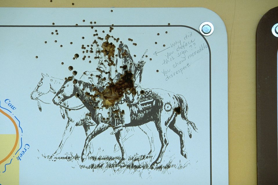 Bullet holes in Kiosk, with a note from a displeased visitor