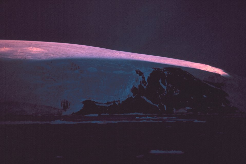  A streak of sunlight illuminates the top of Nansen Island.  64 35 S Latitude 62 06 W Longitude. 